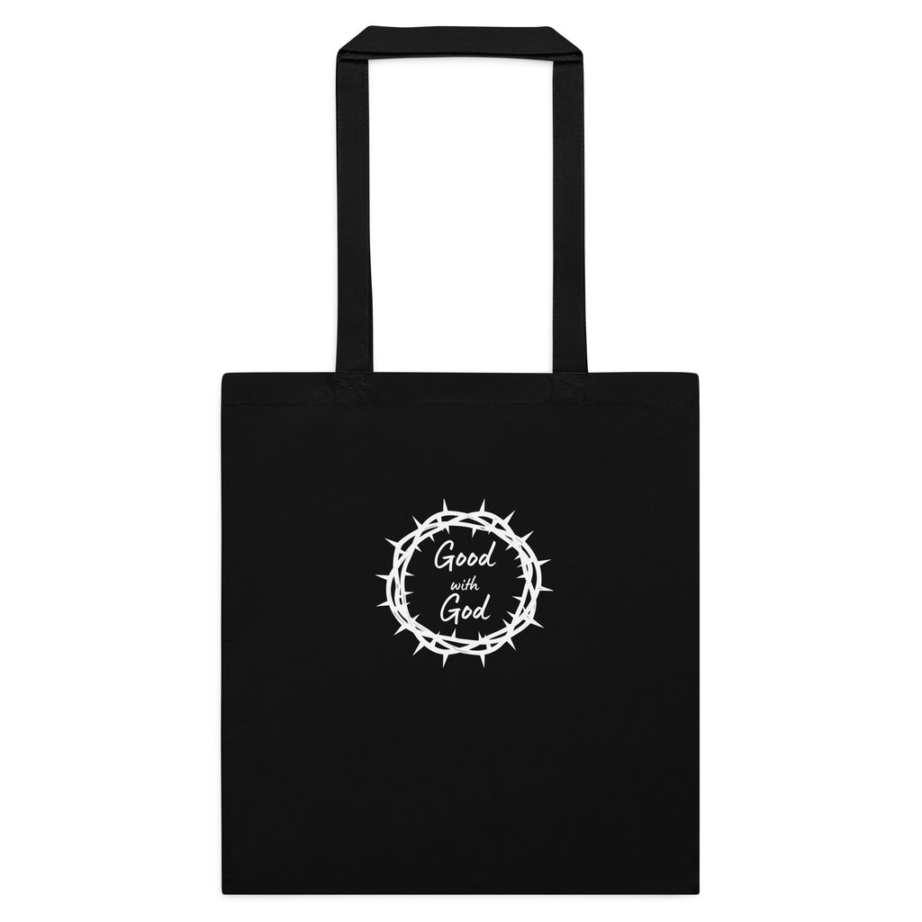 A black canvas tote bag with two black handles, featuring a white graphic in the center of a crown of thorns enclosing the words 'Good with God'.