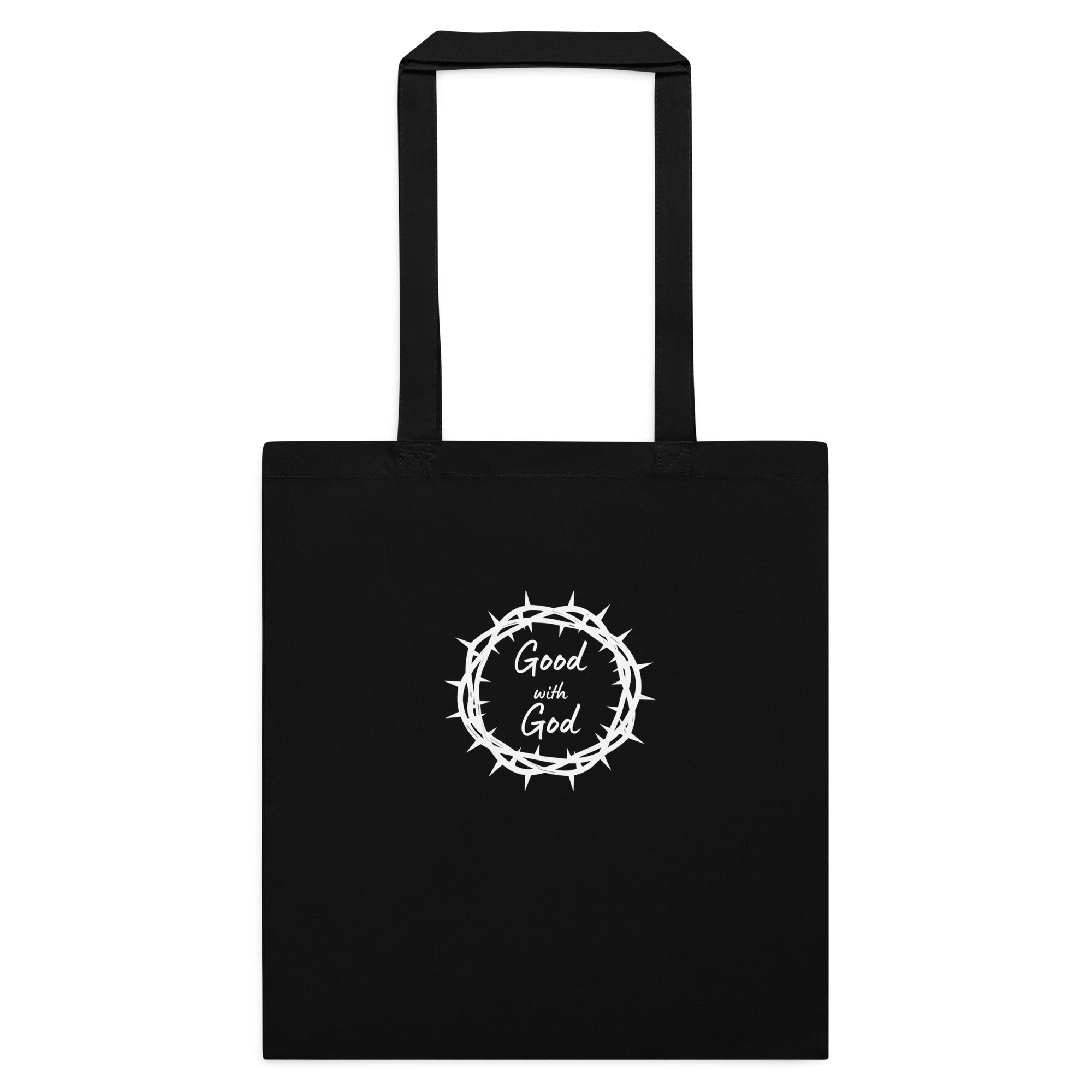 A black canvas tote bag with two black handles, featuring a white graphic in the center of a crown of thorns enclosing the words 'Good with God'.