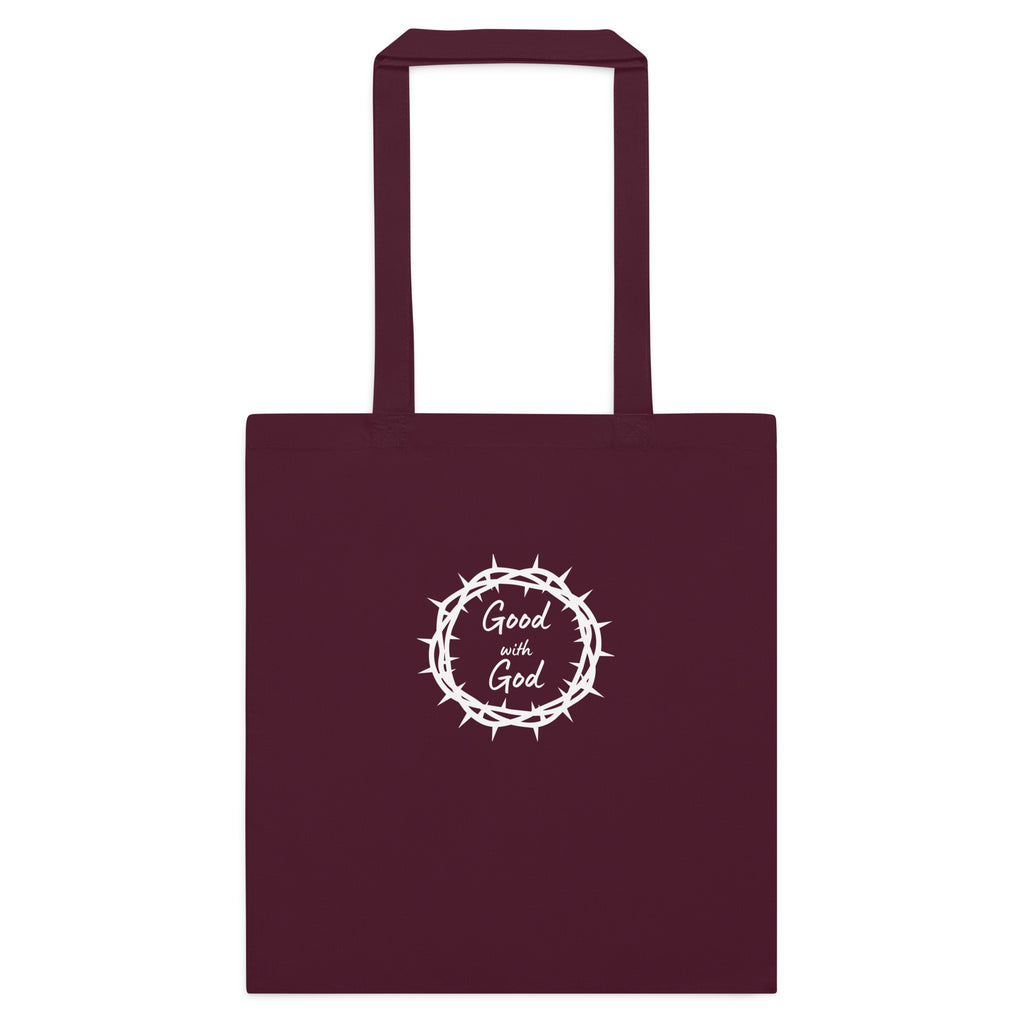 A dark maroon tote bag with two handles, featuring a white graphic in the center of a crown of thorns enclosing the words 'Good with God'.
