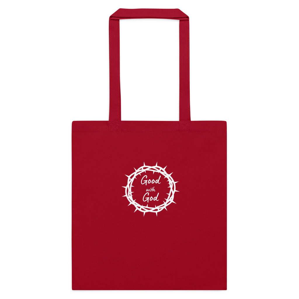 A red canvas tote bag with two top handles, featuring a white circular graphic on the front that reads 'Good with God' inside a crown of thorns design, shown against a plain white background.