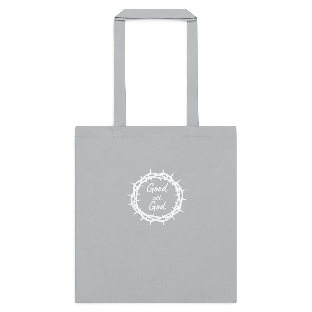 A light gray canvas tote bag with two handles, featuring a white circular graphic in the center with a crown of thorns and the words 'Good with God' written inside.