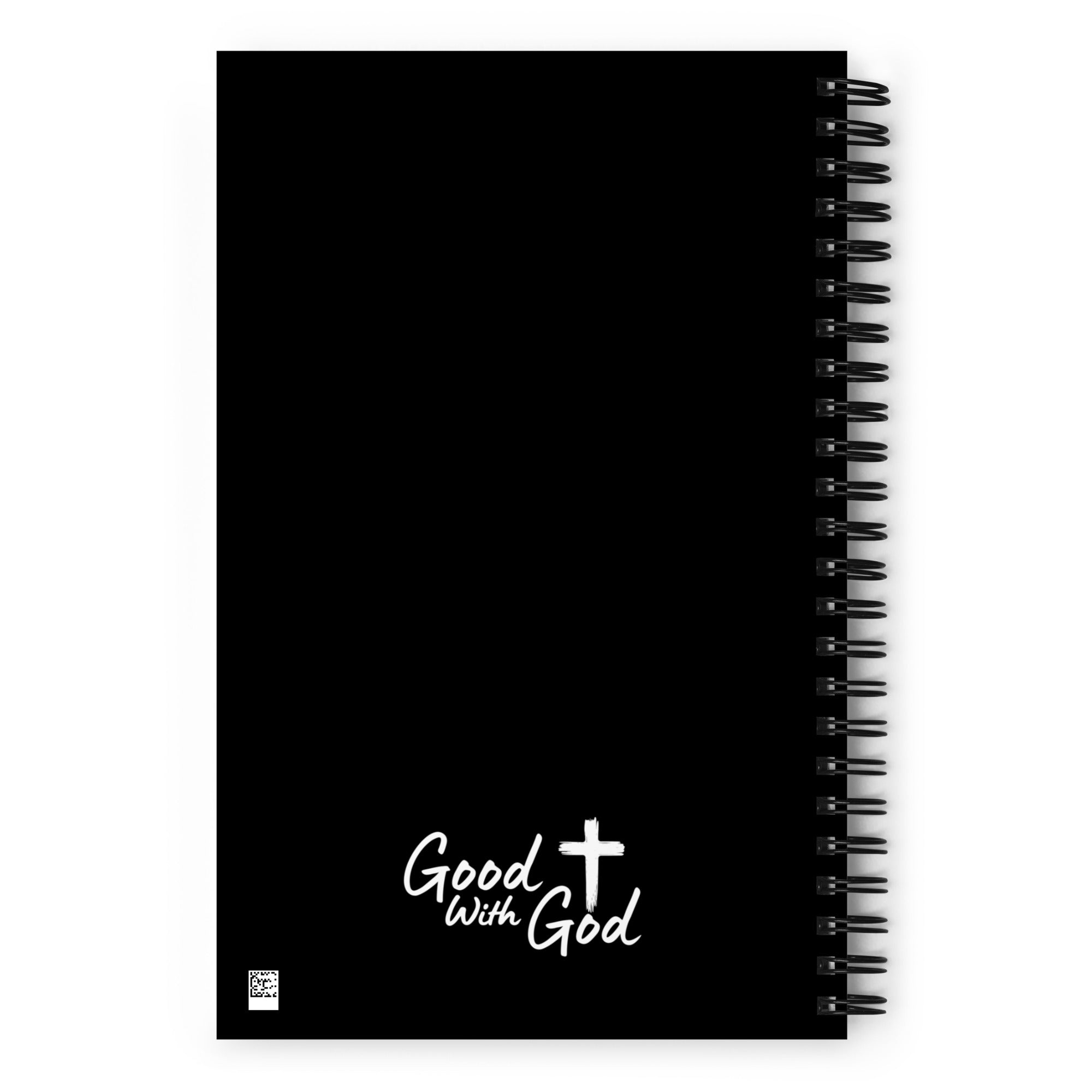 A black spiral-bound notebook with white script text reading 'Good with God' and a white cross on the lower front cover, shown on a plain white background.