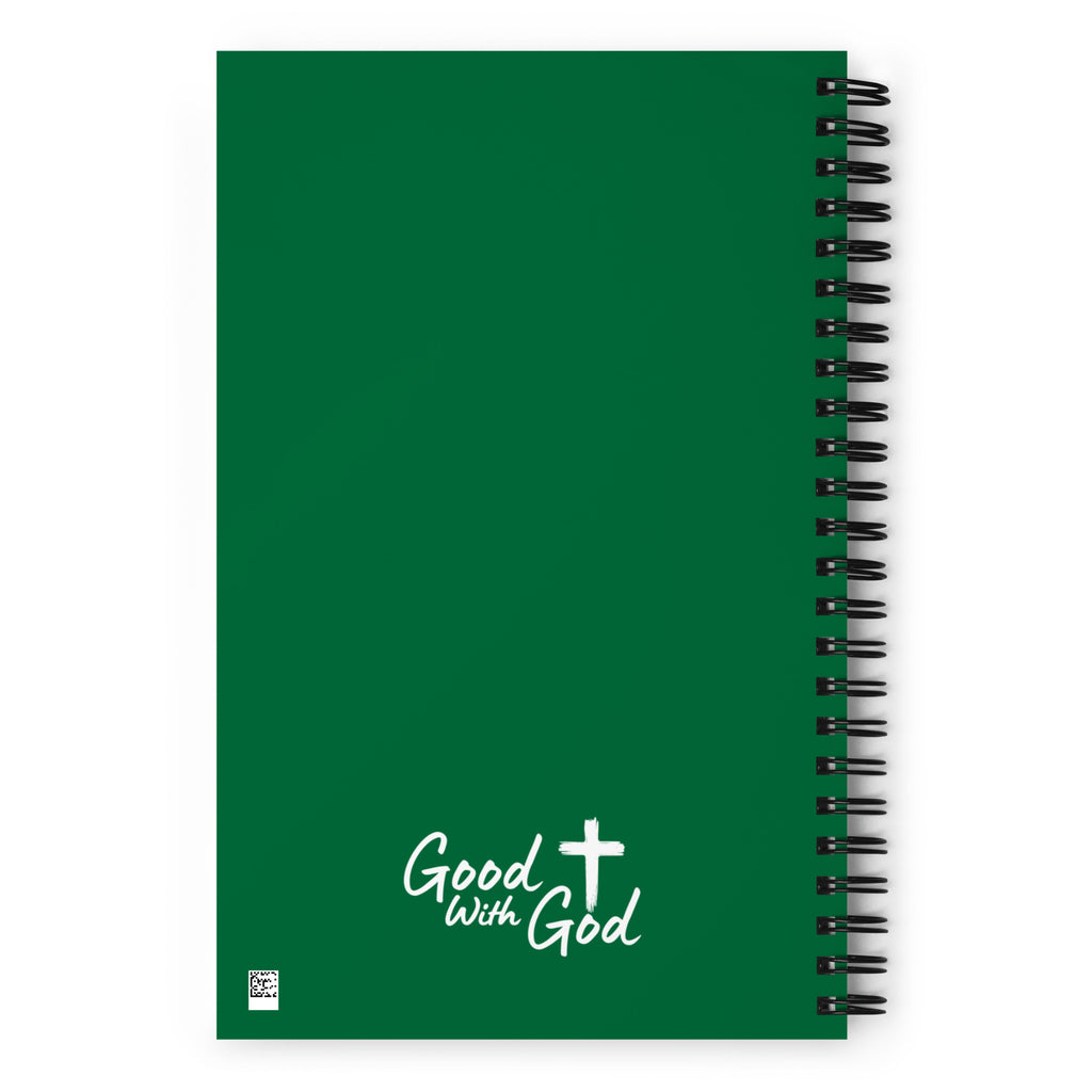 A green spiral-bound notebook with a black wire coil on the right side and white text reading 'Good with God' with a cross symbol near the bottom, shown on a white background.