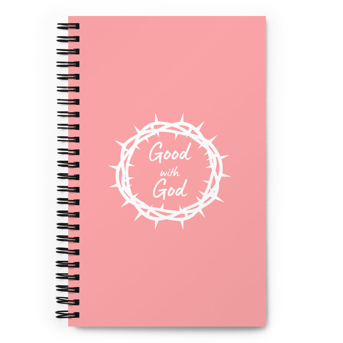 A pink spiral-bound notebook with a black wire binding and a white graphic of a crown of thorns surrounding the words 'Good with God' on the front cover, shown on a white background.
